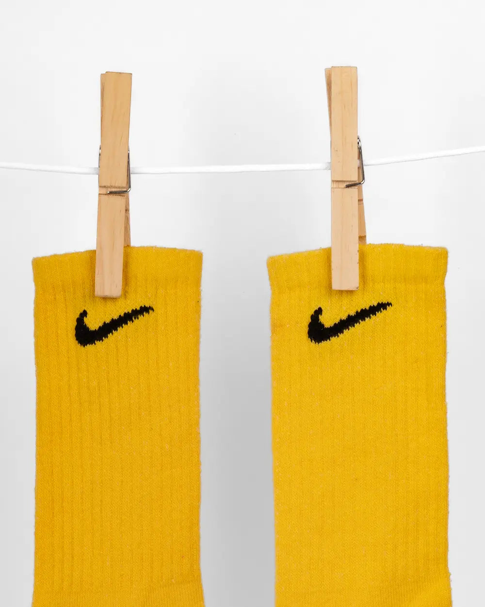 Calzini nike colorati con tecnica di tintura, tonalità Lemon, appesi con due mollette