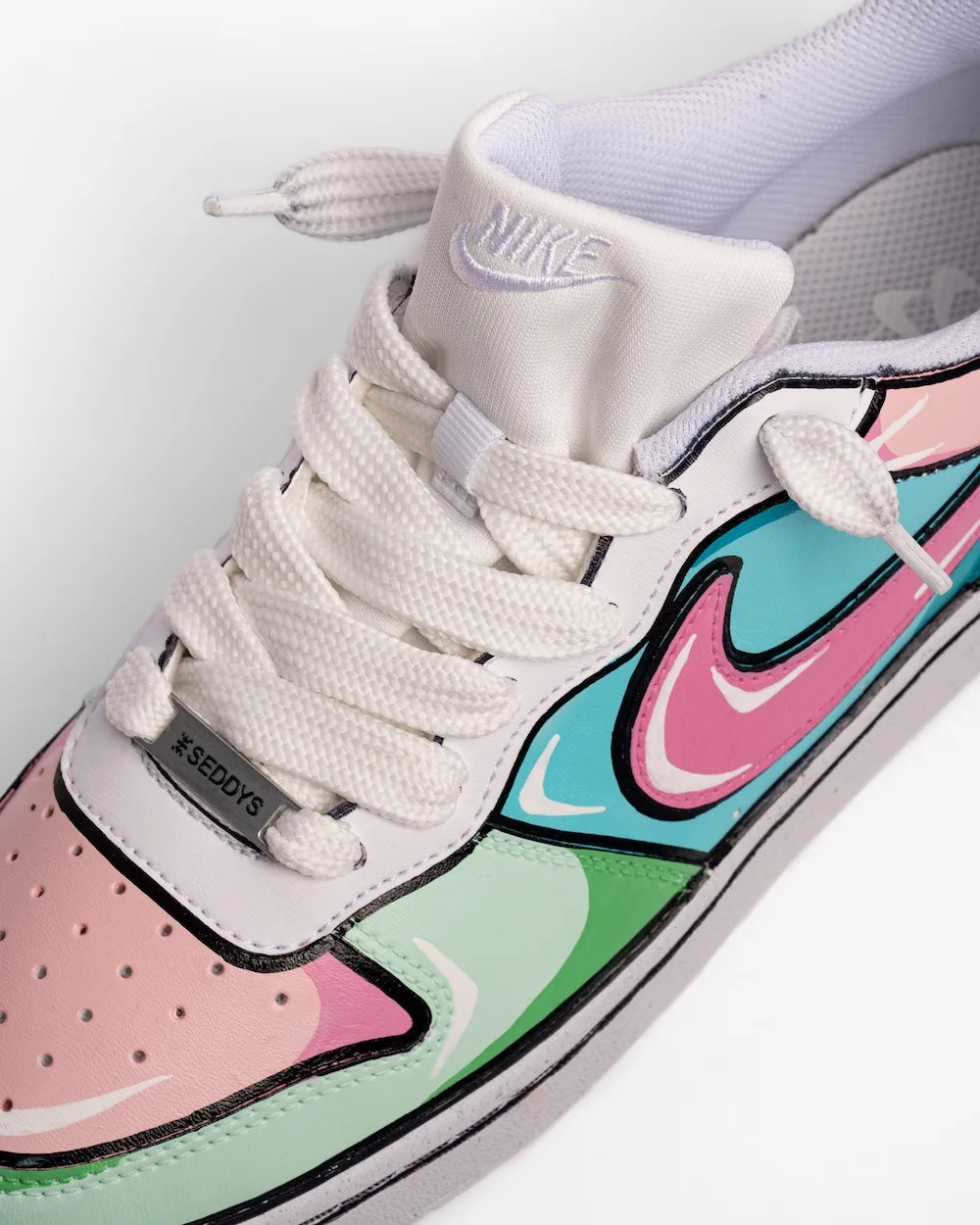 Sneaker Nike personalizzata da SEDDYE effetto fumetto in colore rosa-azzurro-verde