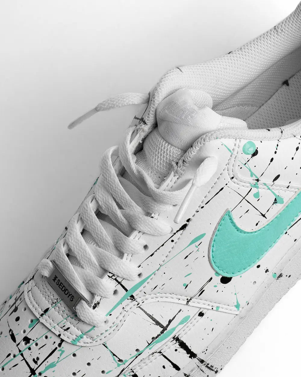 Dettaglio Nike Court Vision dipinta a mano con Swoosh e schizzature di colore verde acqua 