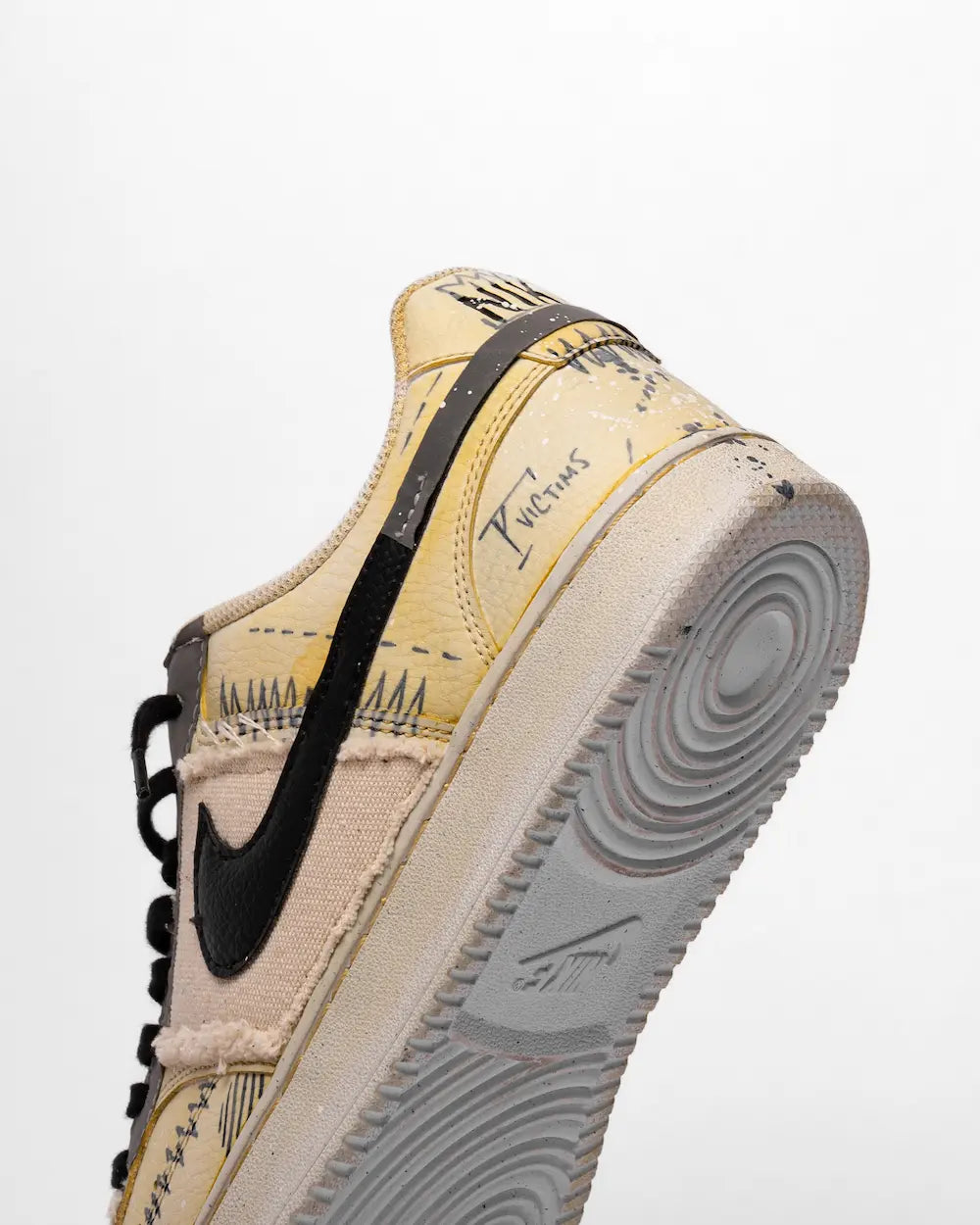 Nike Court Vision decorata con scritte, simboli, piccoli disegni, stencil e tessuti, nelle tonalità giallo e nero (tacco)