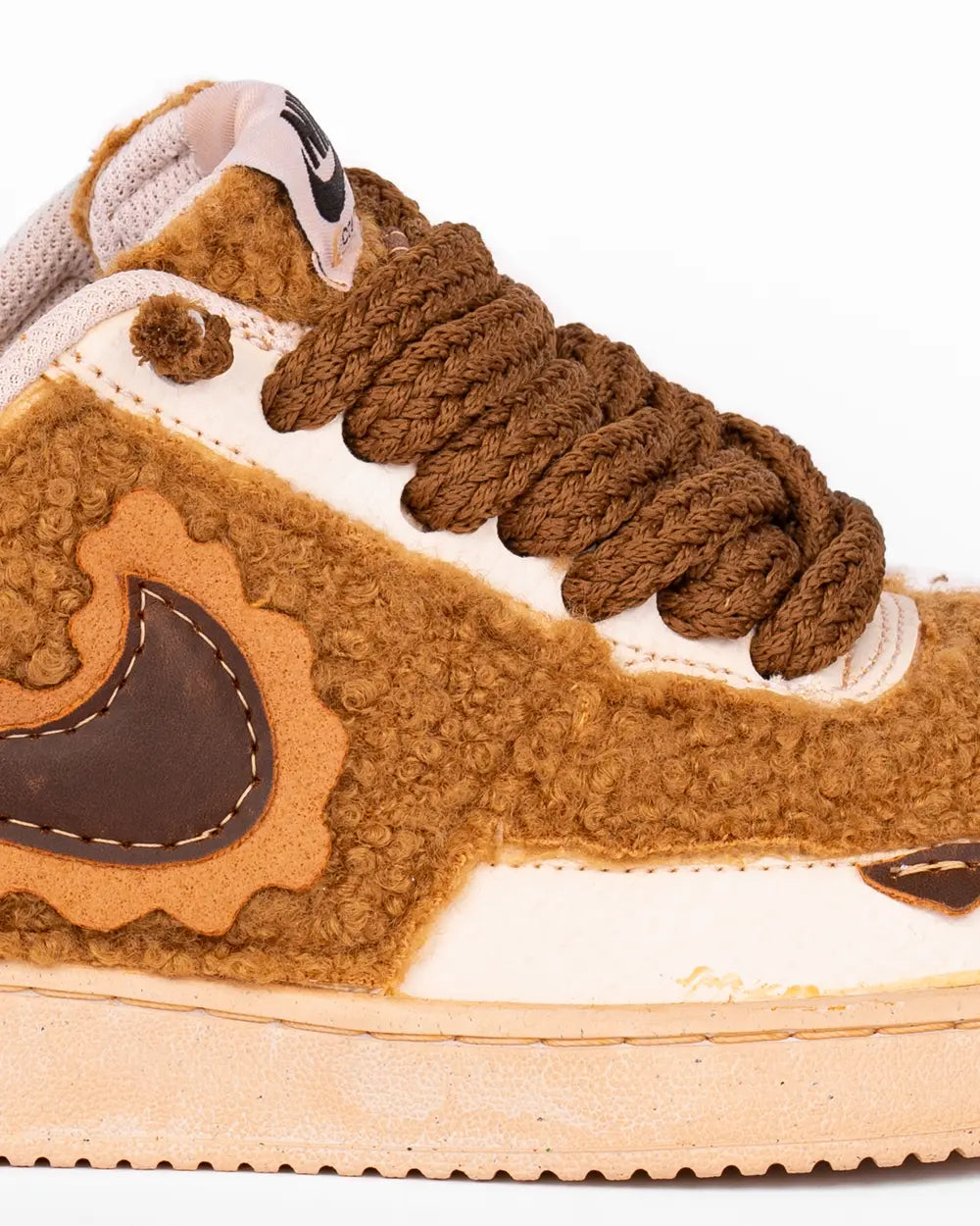 Dettaglio: Nike Court Vision rivestita con tessuto morbito teddy marrone, lacci grossi intrecciati marroni